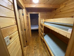 cabin interior with bunk beds and a door leading to a bedroom